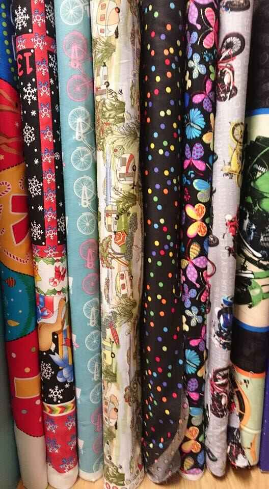 Various colourful fabrics with patterns and designs like bicycles, motorcycles, butterlfies and campervan scenery. Photo