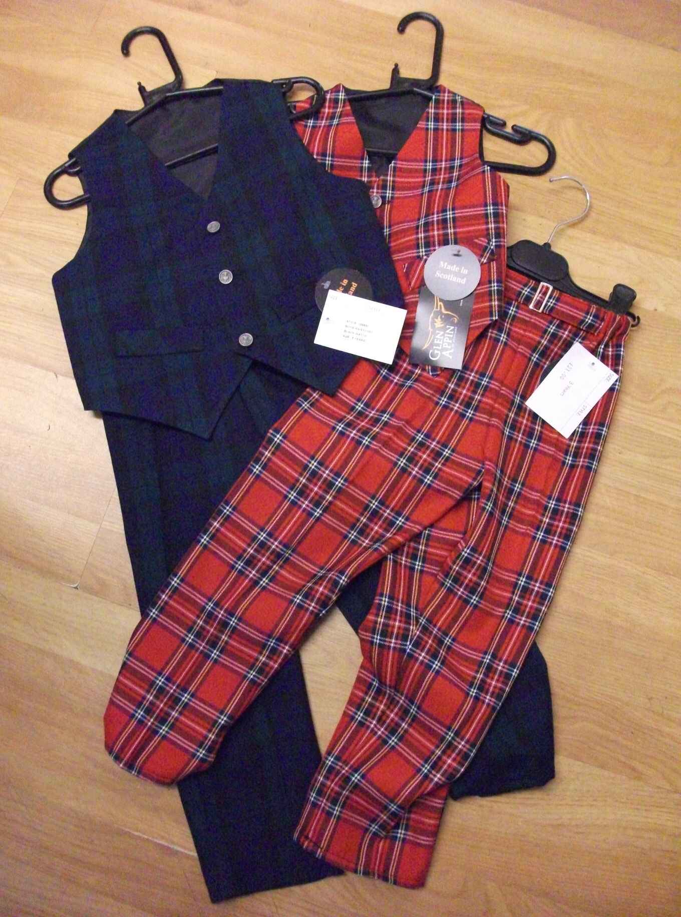 Two boys tartan oufits, one blue and one red tartan with waistcoat and trousers. Photo