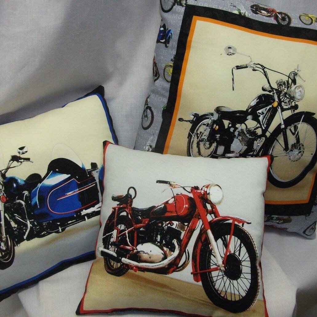 Three cushions each with a different old motorcycle printed on the fabric. Photo