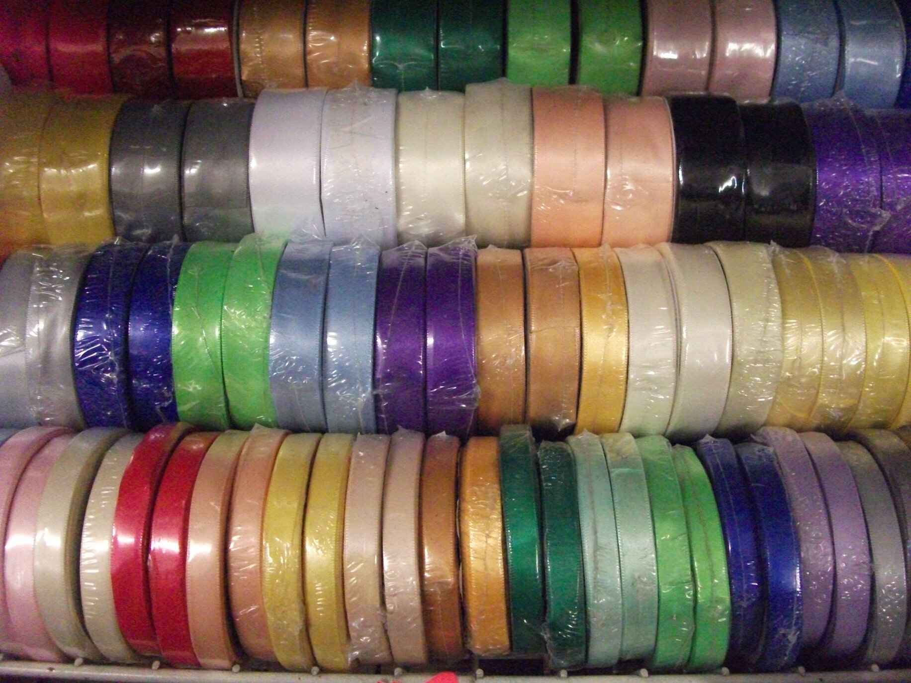 Four rows of different colour and width ribbons. Photo