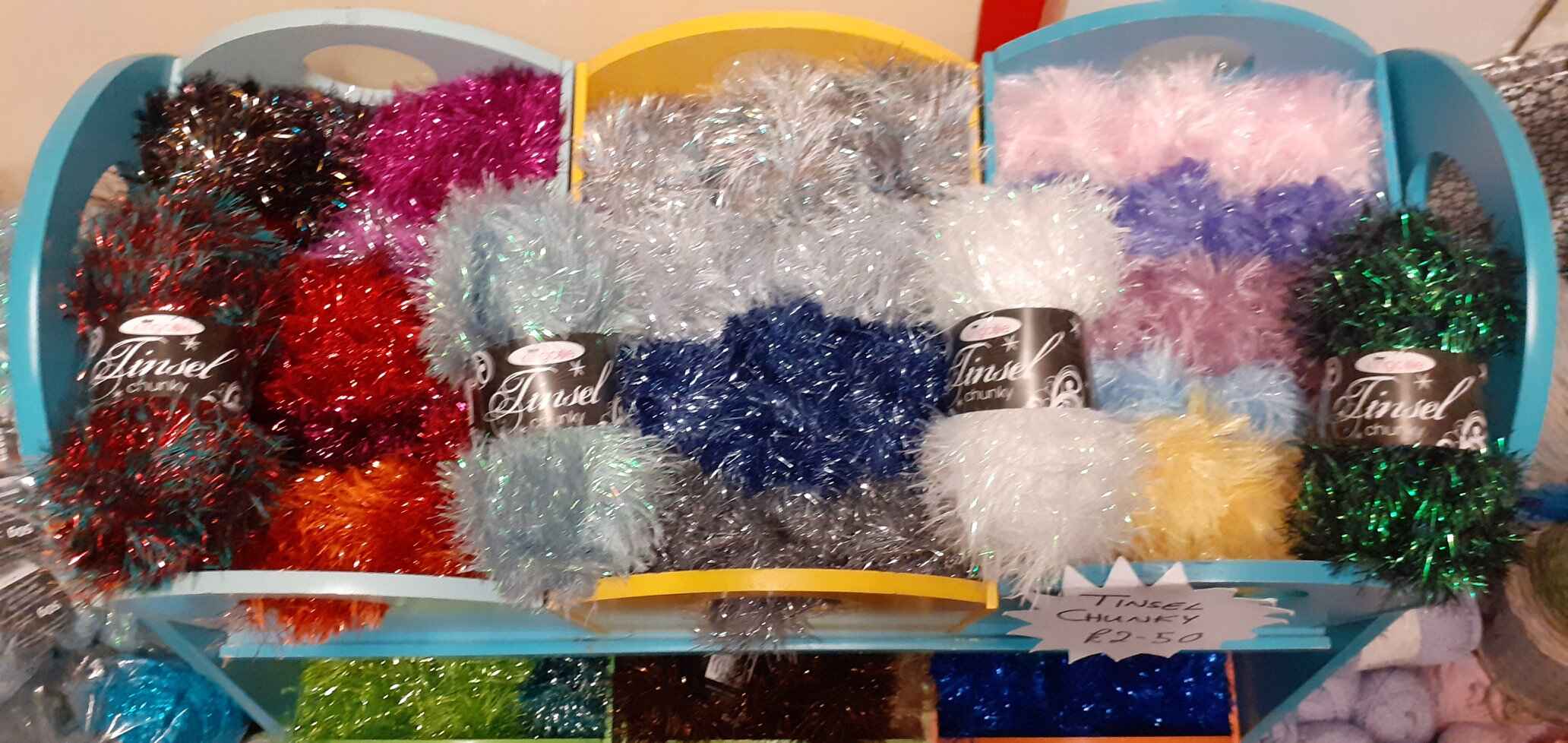 Boxes filled with different colour wool that looks like shiney tinsel. Photo