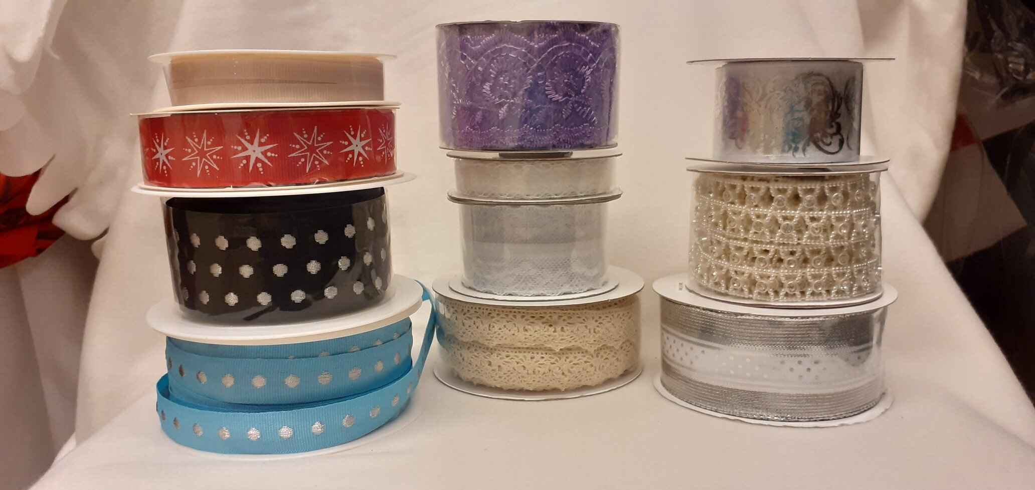 Three stacks of various colourful ribbons with winter themes. Photo